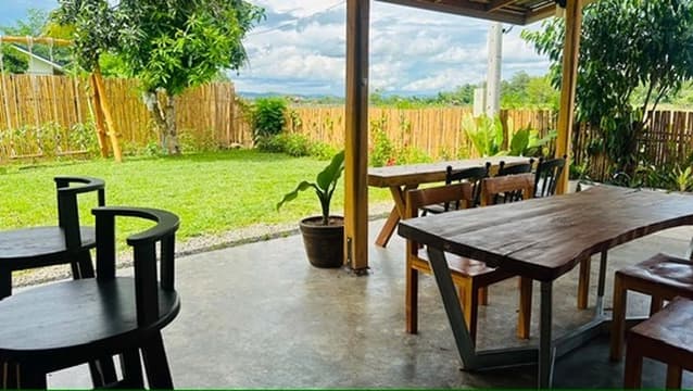 An outdoor dining table looking across the field toward distant blue hills.